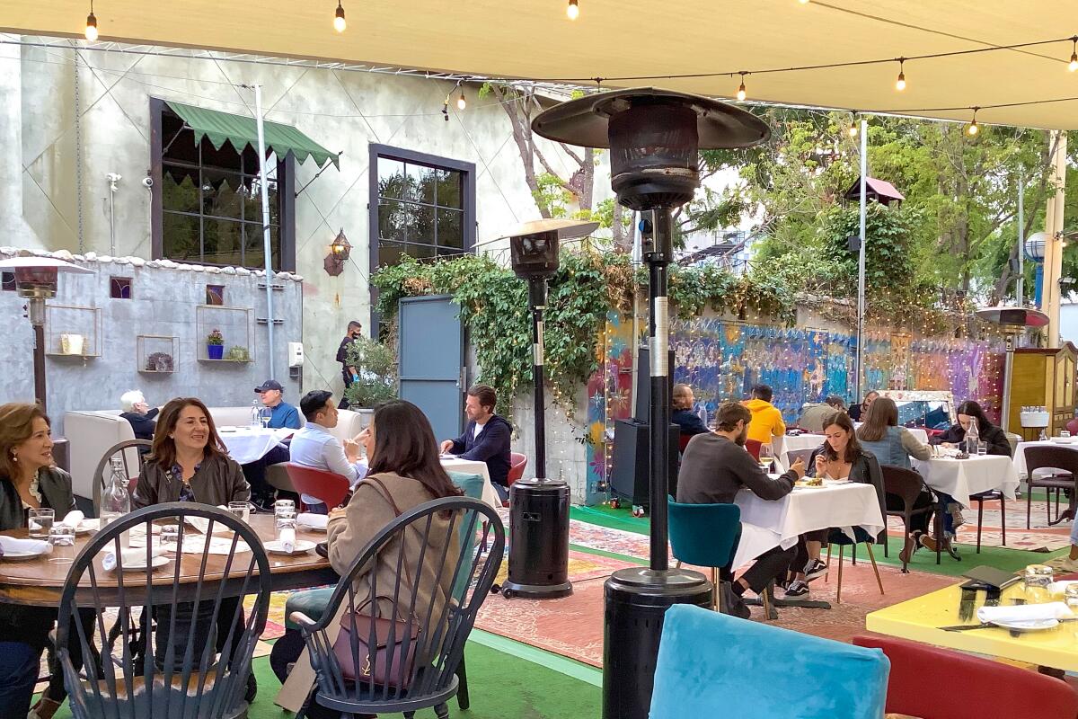 Patrons enjoy their food in La Bohème's outdoor parking lot, which has been converted into a bohemian paradise.