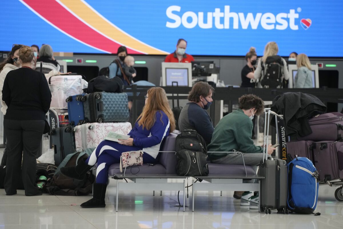 Travelers check in at the Southwest Airlines counter as the Thanksgiving Day holiday approaches Tuesday, Nov. 23, 2021, at Denver International Airport in Denver. Southwest Airlines says travel was strong over Thanksgiving and that momentum is carrying into December. The airline said Wednesday, Dec. 8, 2021 that as a result, it's offering a better forecast for fourth-quarter revenue — although the current quarter will still be weaker than the same period in 2019, before the pandemic hit. (AP Photo/David Zalubowski, file)