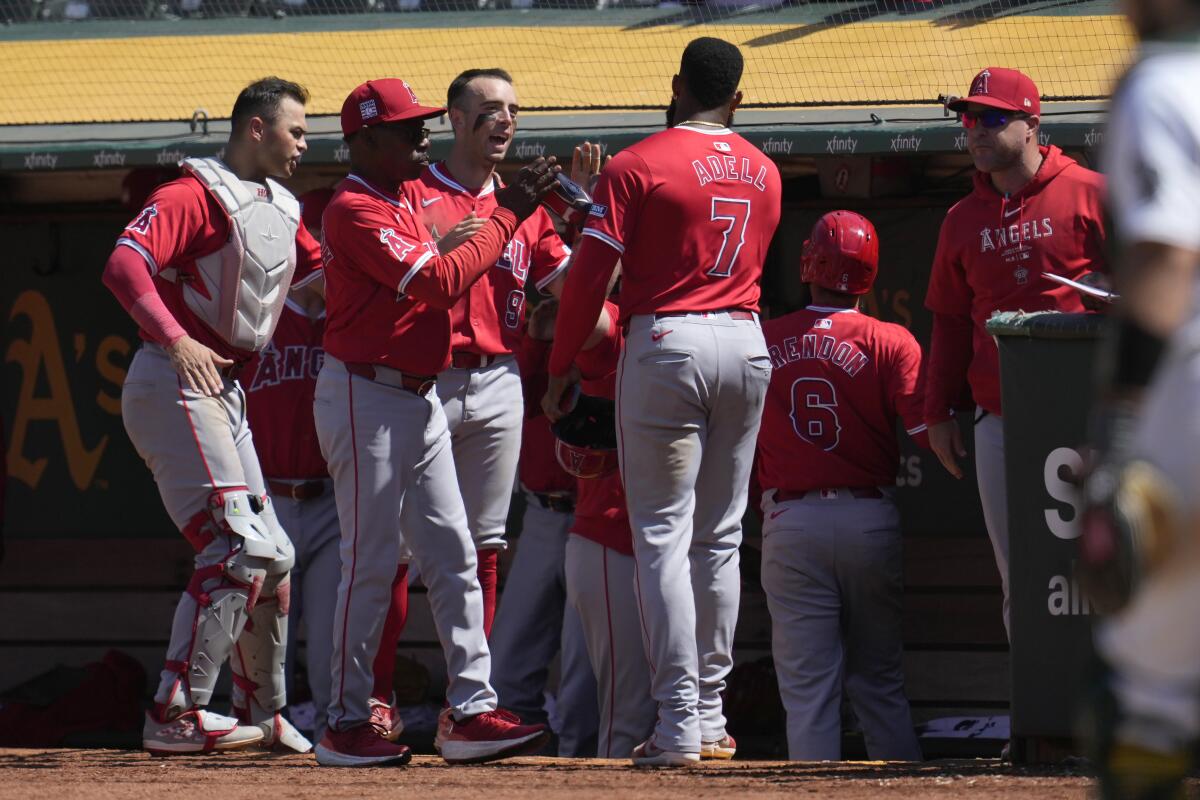 Jo Adell (7) is congratulated by Angels manager Ron Washington, second from left, and his teammates.