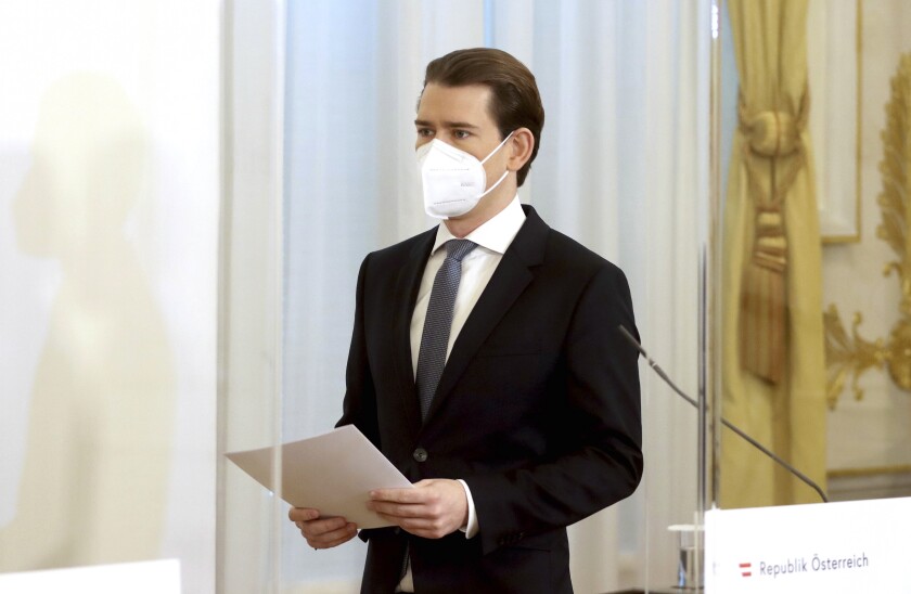 Austrian Chancellor Sebastian Kurz with a face mask walks at the federal chancellery in Vienna, Austria, Sunday, Jan. 17, 2021. The Austrian government has moved to restrict freedom of movement for people, in an effort to slow the onset of the COVID-19 coronavirus. (AP Photo/Ronald Zak)