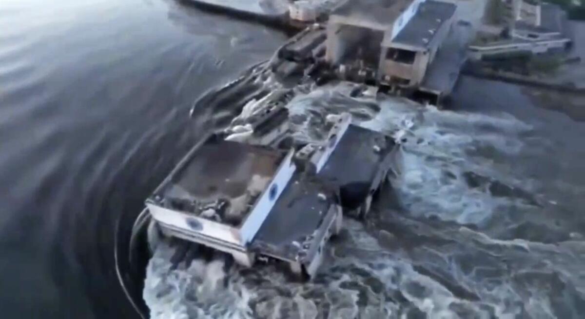 Water pouring through breach in dam