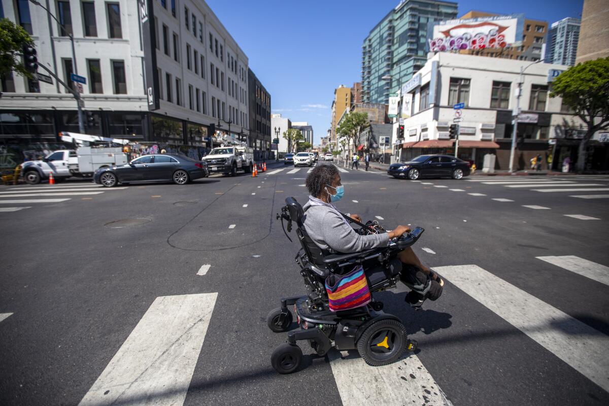 Engracia Figueroa crosses a Los Angeles street in June 2021.