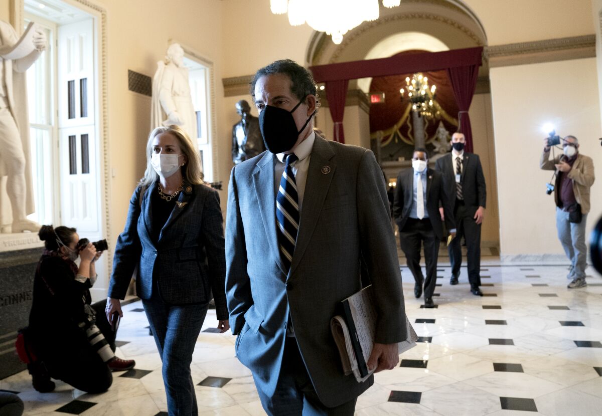 Rep. Jamie Raskin walks with other masked lawmakers in the Capitol.