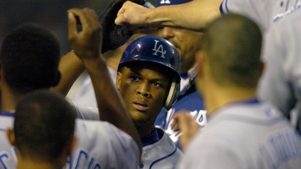 Adrian Beltre is congratulated by his Dodgers teammates in the dugout after hitting a home run against the Angels on July 23, 2004.