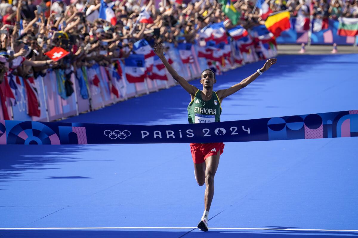 Ethiopia's Tamirat Tola celebrates as he crosses the finish line to win the Olympic men's marathon in Paris on Saturday.