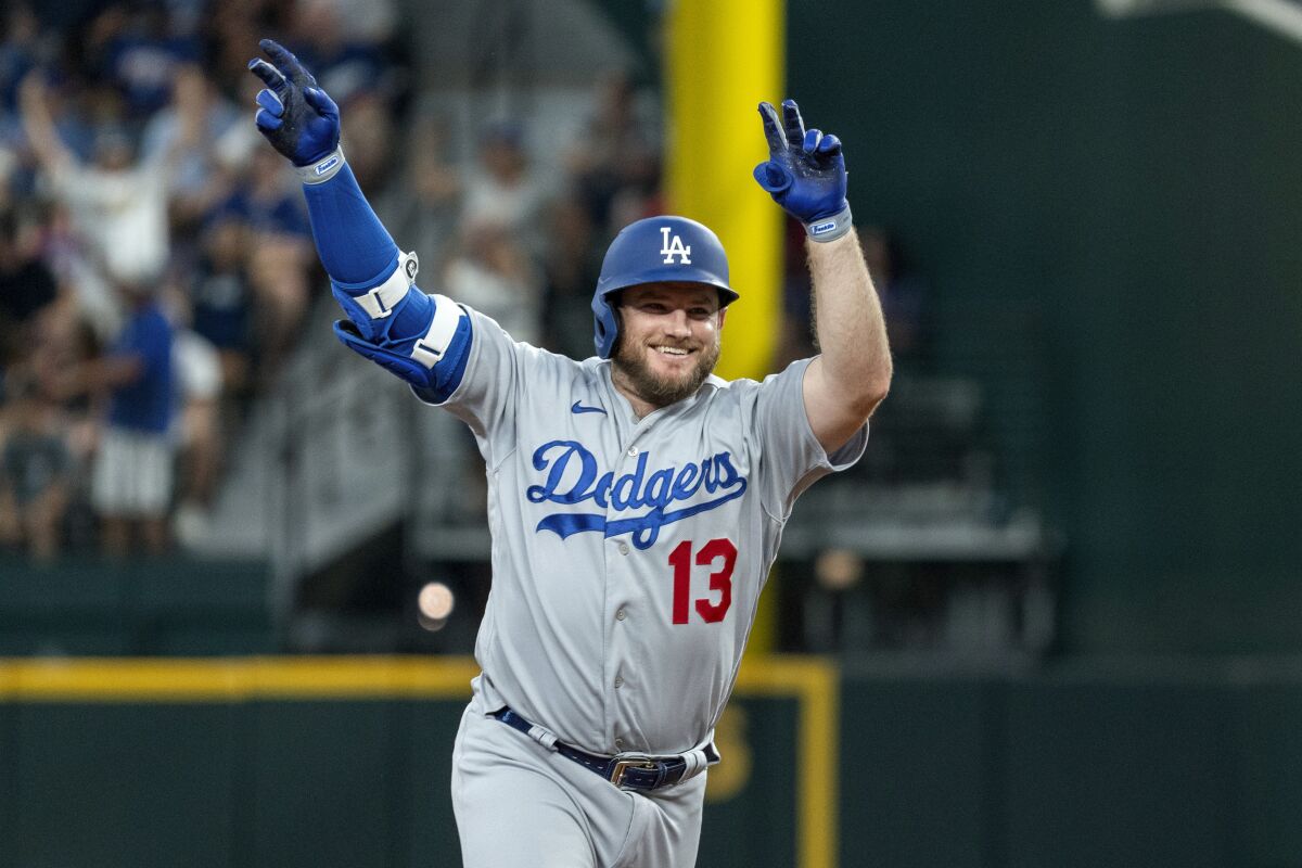 Max Muncy celebrates after hitting a solo home run in the third inning against Rangers on Saturday.