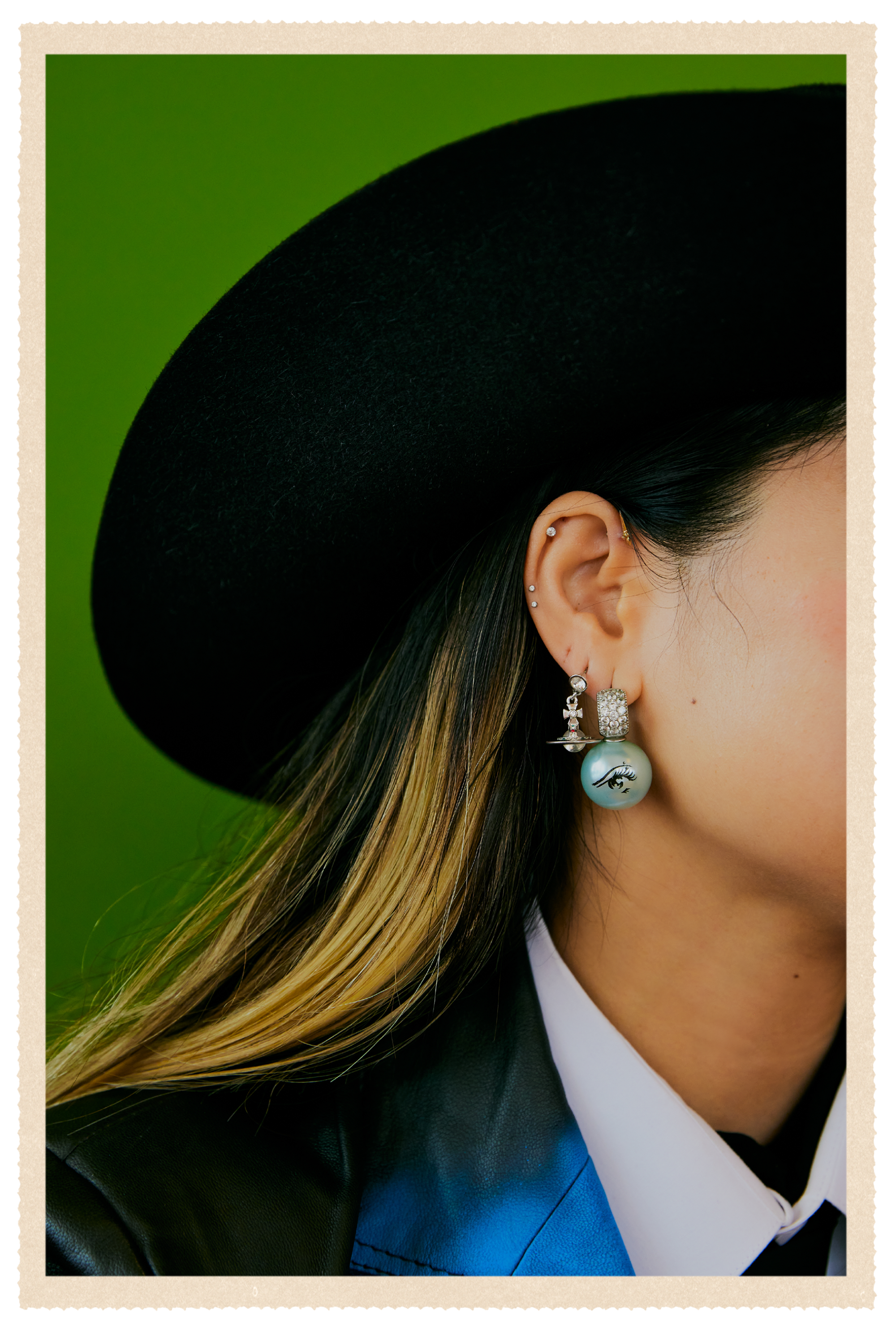 A detail shot of Ann-Marie Hoang's black hat and earrings.