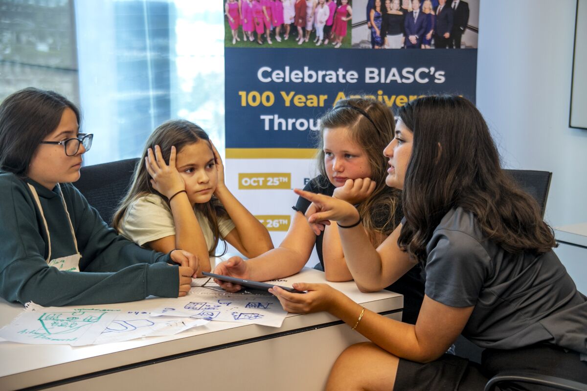 Mia Montejano, right, works with 11-year-old twins Claire and Amelia Casanova and Maryn Knecht, also 11. 