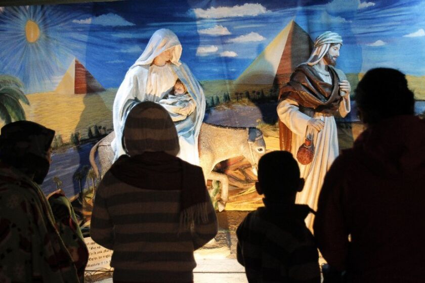 People look at the restored Nativity display during December Nights at Balboa Park in San Diego.