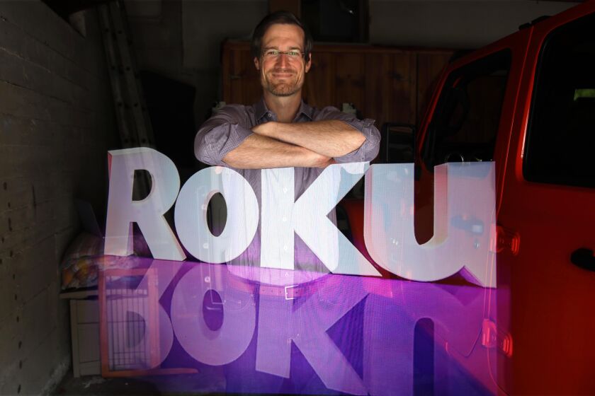 LOS ANGELES, CA - MAY 12, 2020 - - Rob Holmes Vice President of Programming and Engagement for Roku, stands over the company logo is this double-exposure made at his home in Los Angeles on May 12, 2020. Roku has seen strong growth in the amount of time people are streaming content on its platform. Roku has benefited from more people staying at home, but it has also been hurt by the weaker advertising market, with some advertisers like travel pulling out due to COVID-19. One of the areas of growth for Roku is its streaming channel, The Roku Channel, that offers free, ad-supported content. vLos Angeles on Tuesday, May 12, 2020 Los Angeles, CA. (Genaro Molina / Los Angeles Times)