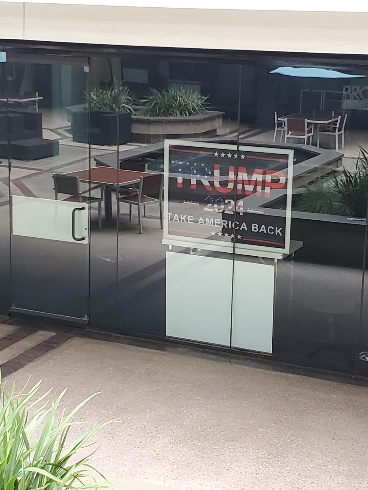 Signs posted in the Merrill Lynch building in La Jolla show support for Donald Trump's 2024 presidential campaign.