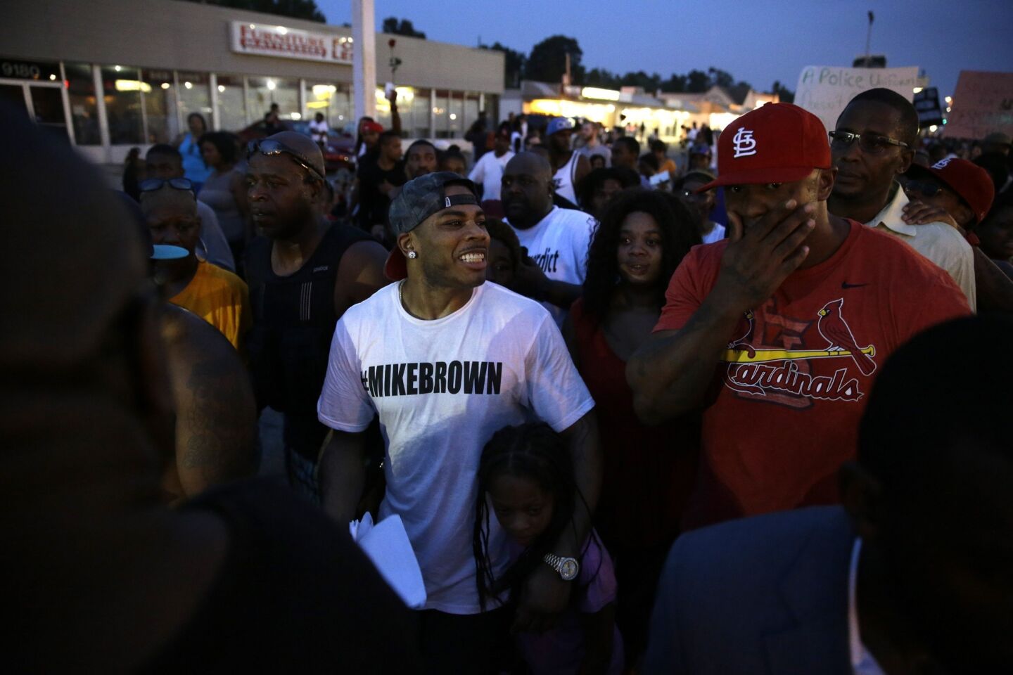 Rapper Nelly, center, walks with protesters Monday in Ferguson, Mo.