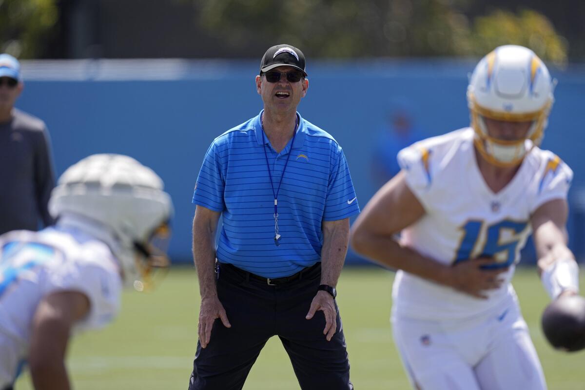 Chargers coach Jim Harbaugh, center, watches a drill during an offseason workout of rookies on Friday.