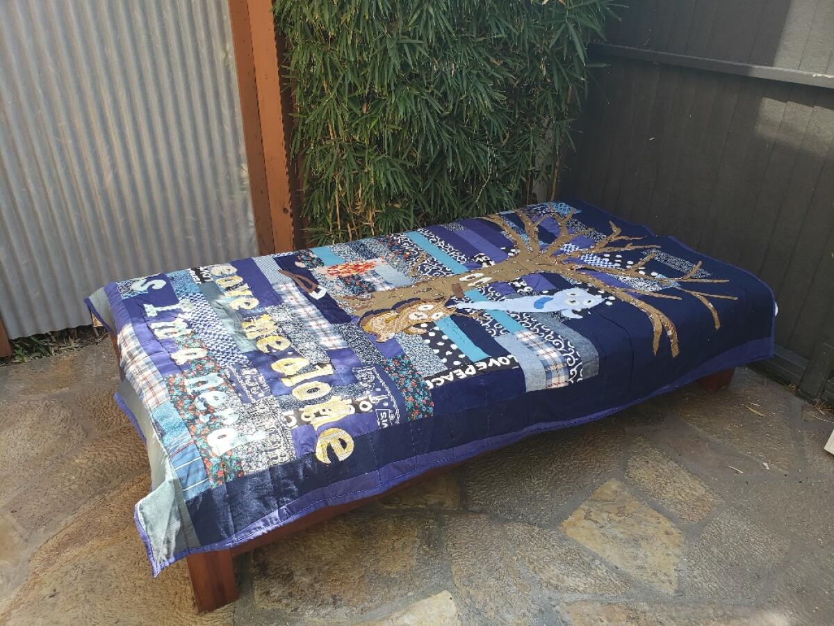 A poignant cross-cultural quilt by Atsushi Kaga is spread out on a cabana daybed.