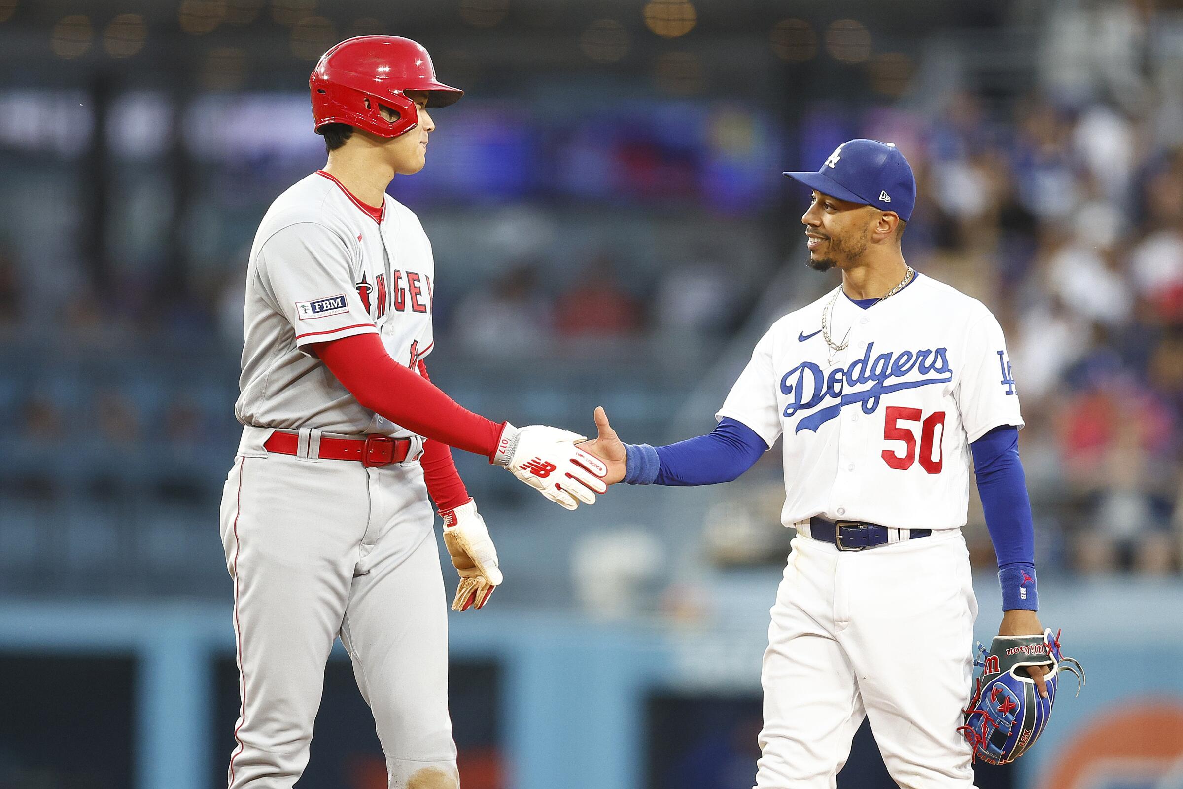 Angels’ Shohei Ohtani, left, and Dodgers’ Mookie Betts shake hands during a July 7 game at Dodger Stadium.