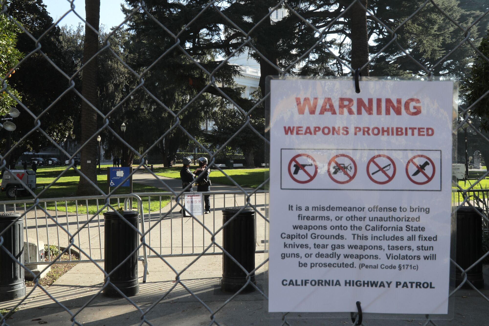 A warning sign hangs on the temporary protective fencing at the California State Capitol.