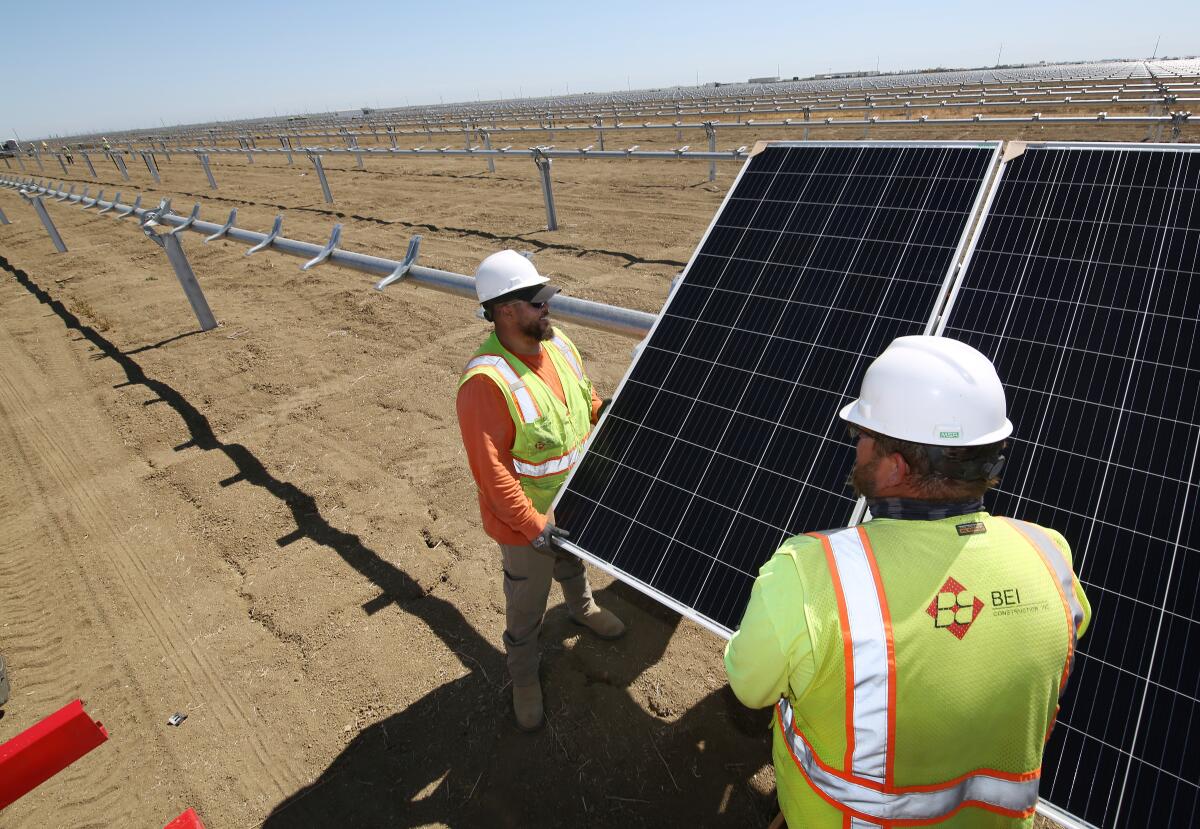 Workers place panels at the construction site of Westlands Solar Park in California's San Joaquin Valley.