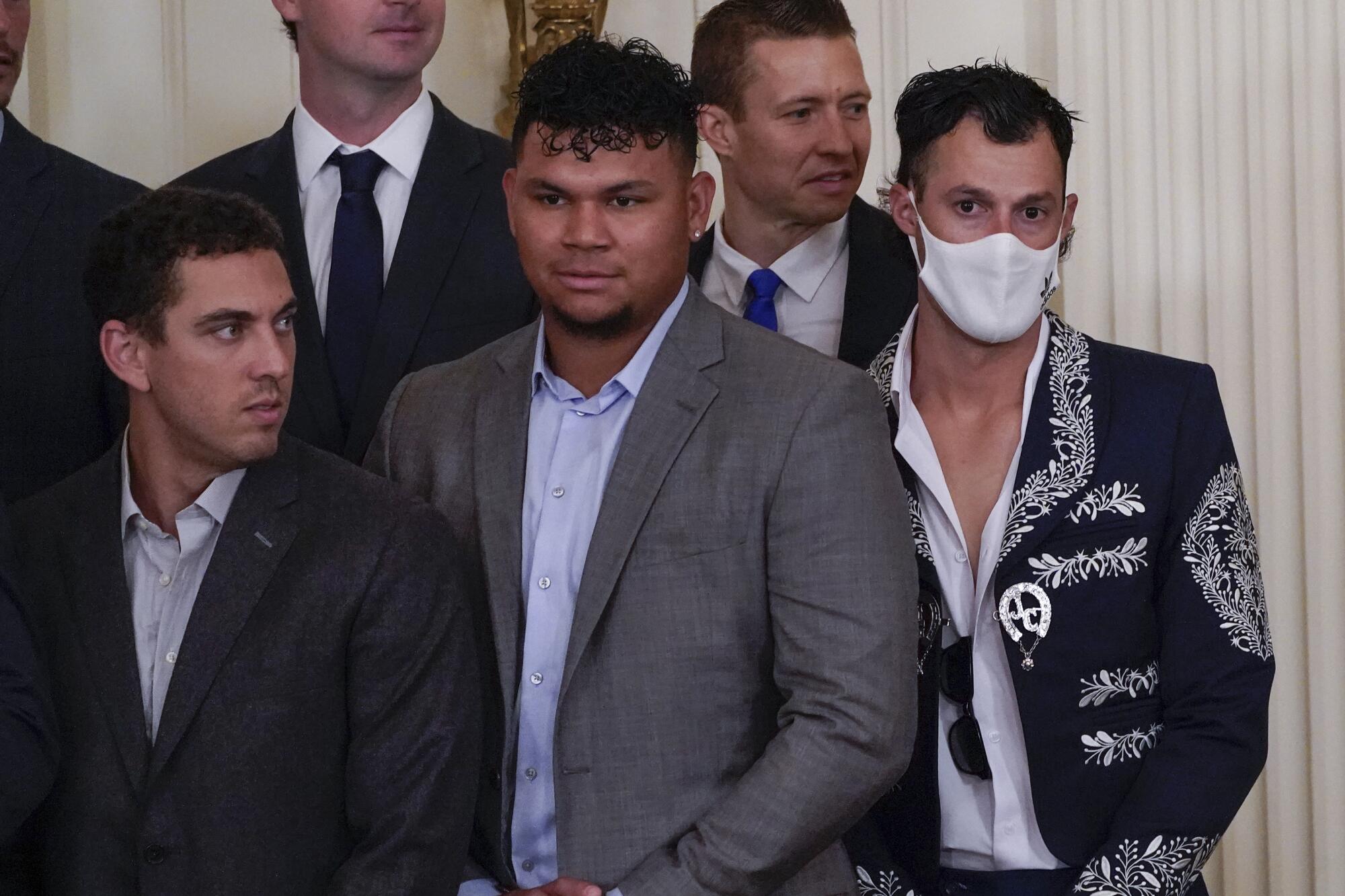 A group of men in suits and a man in a mariachi jacket