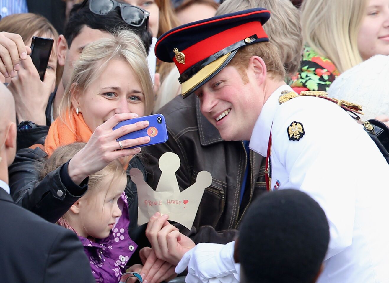 A member of the public takes a selfie with Prince Harry as he meets locals in Freedom Square on May 16, 2014, in Tallinn, Estonia.