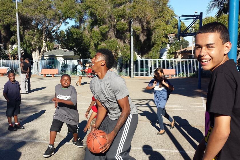 Nick Young shoots around with children at a back-to-school event he hosted at Robertson Park.