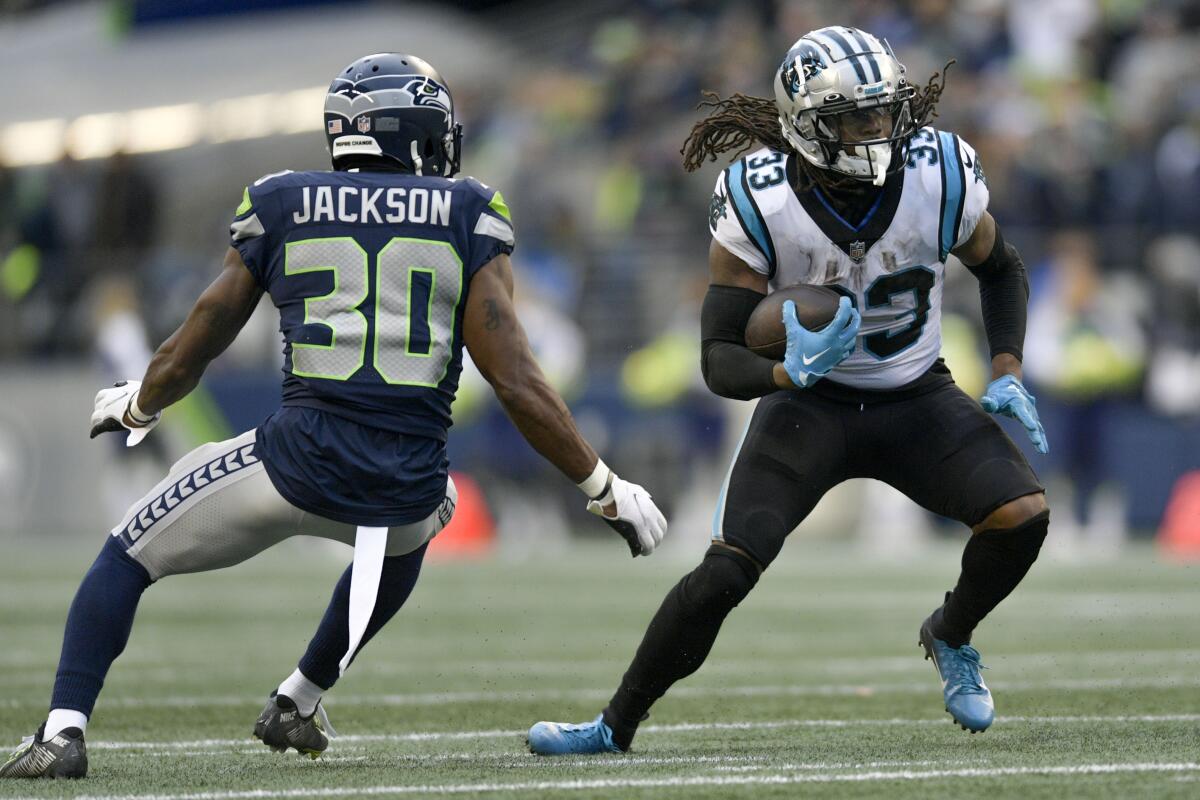 Carolina Panthers running back D'Onta Foreman (33) runs against Seattle Seahawks cornerback Mike Jackson (30) during the second half of an NFL football game, Sunday, Dec. 11, 2022, in Seattle. (AP Photo/Caean Couto)