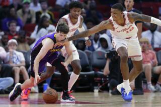 Lakers guard Austin Reaves reaches for a loose ball as Rockets forward Jabari Smith Jr. hits him in the face as he reaches.