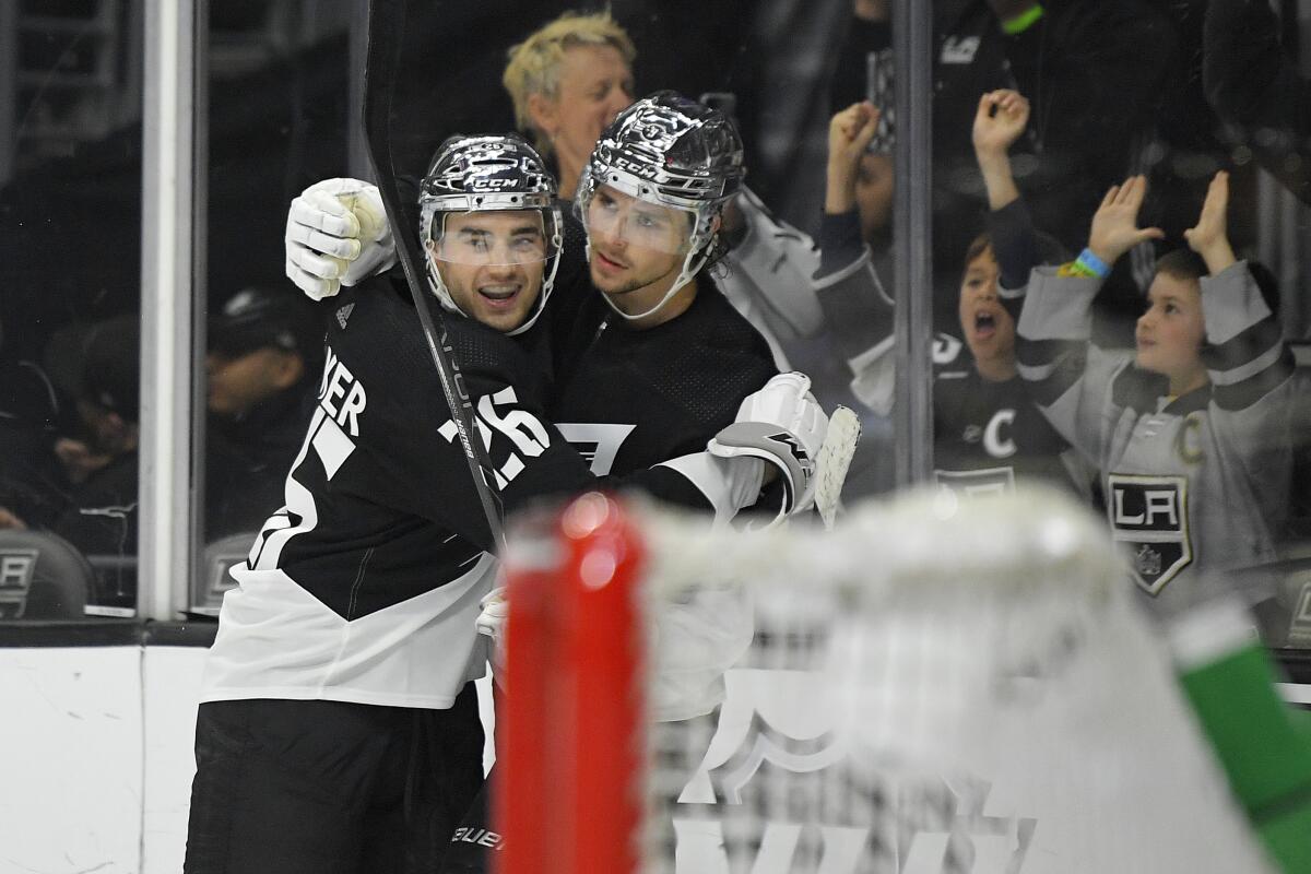 Kings center Adrian Kempe, right, celebrates his overtime goal with defenseman Sean Walker.