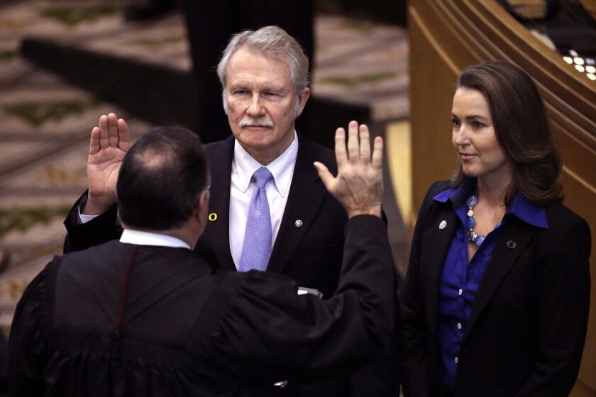 Oregon Gov. John Kitzhaber is joined by his fiancee, Cylvia Hayes, as he is sworn in Jan. 12, 2015, for a fourth term. Kitzhaber has come under fire for actions by Hayes.