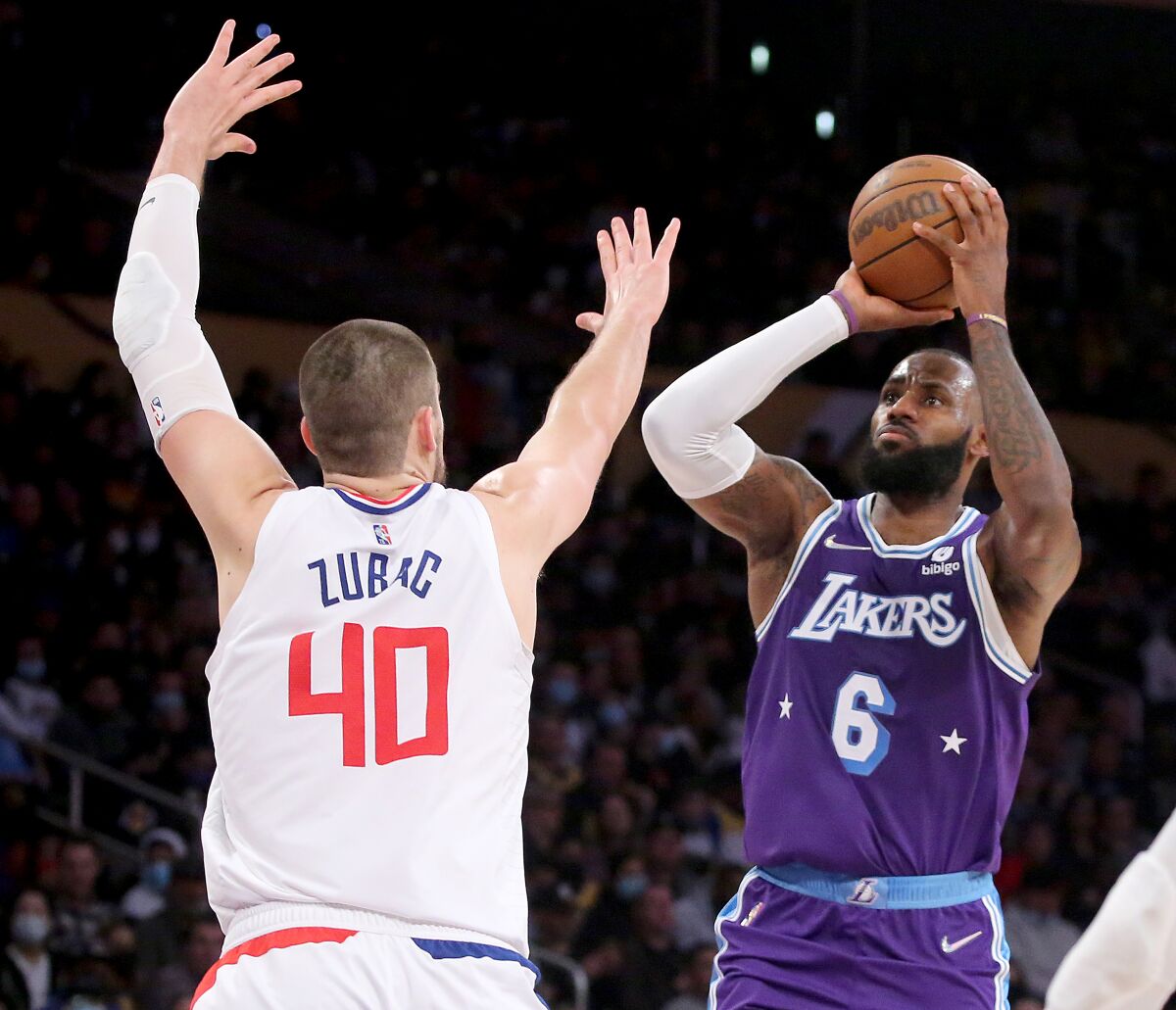 Lakers forward LeBron James, right, shoots over Clippers center Ivica Zubac.