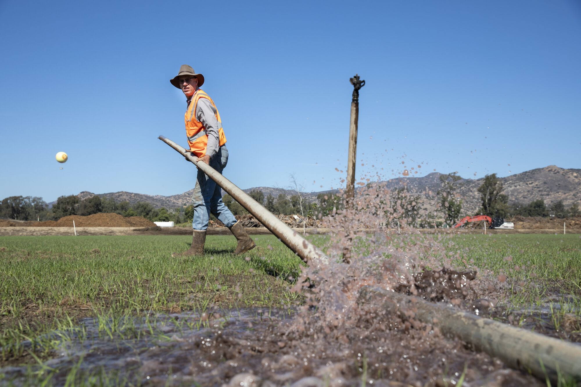 Frank Konyn changes an irrigation line in a field of rye grass on his dairy farm in the San Pasqual Valley.
