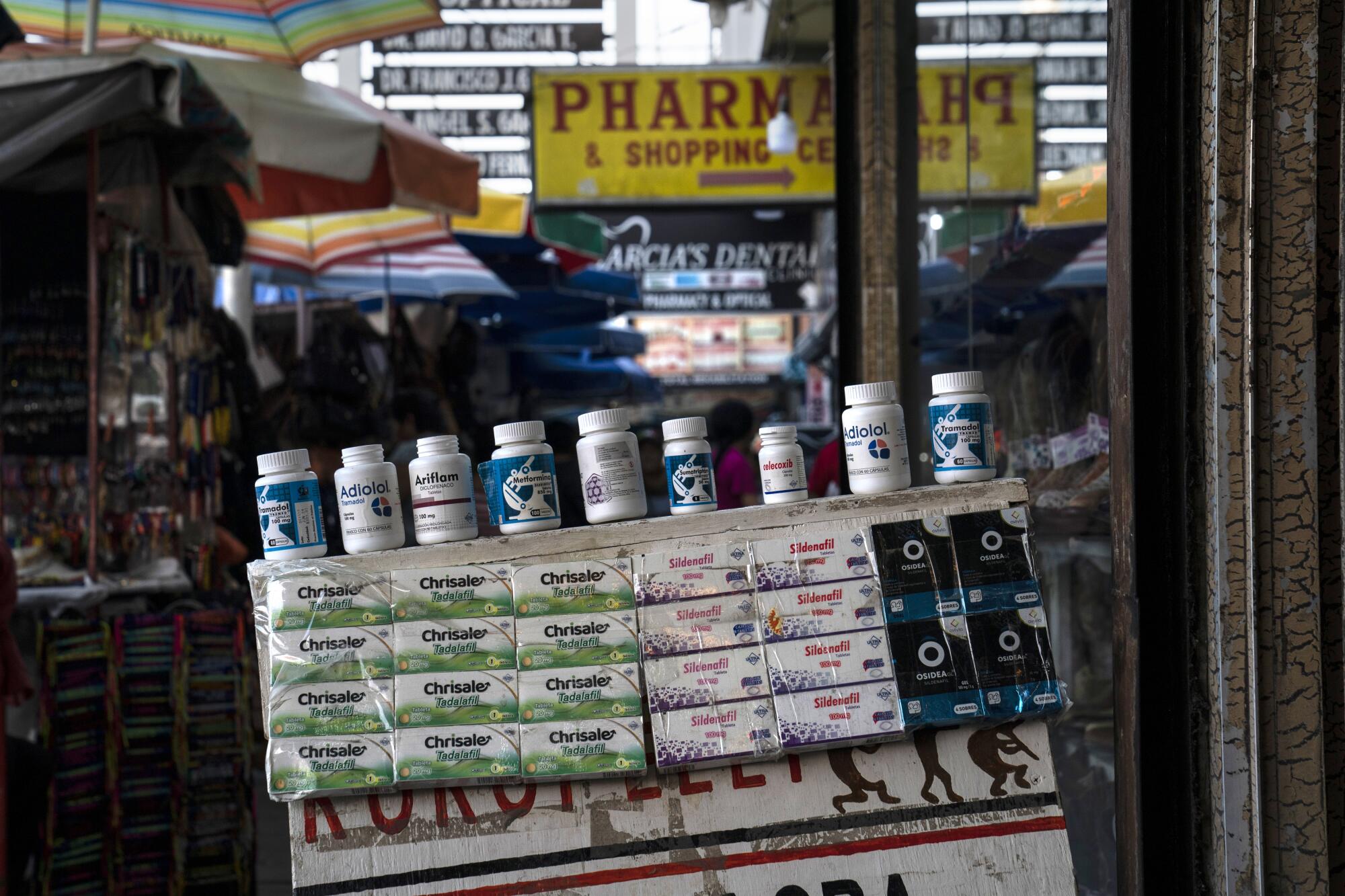 Empty medication bottles and containers are displayed outside a business in Nuevo Progreso.