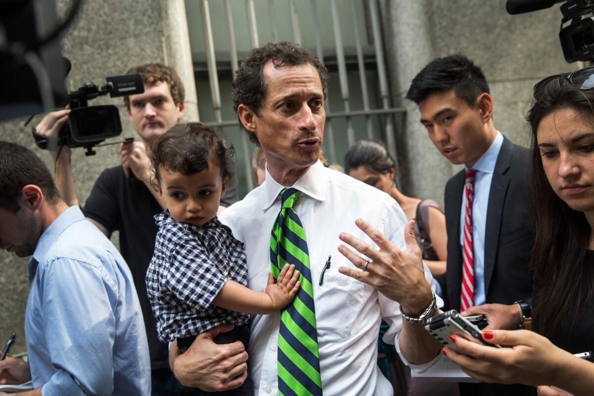 Holding his son Jordan, Anthony Weiner speaks to reporters after voting in September's mayoral primary.