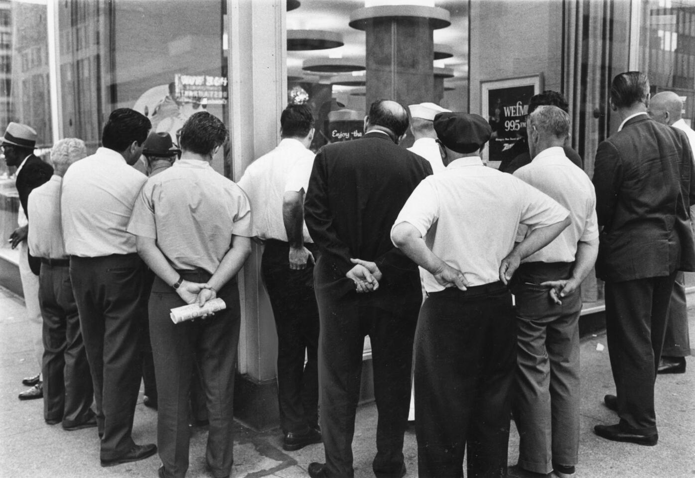 Spectators crowd around a display window of a Chicago store on July 20, 1969 at Michigan Avenue and Lake Street to watch television sets as Apollo 11 astronauts prepare to step on the moon. (William Bender/Chicago Tribune)