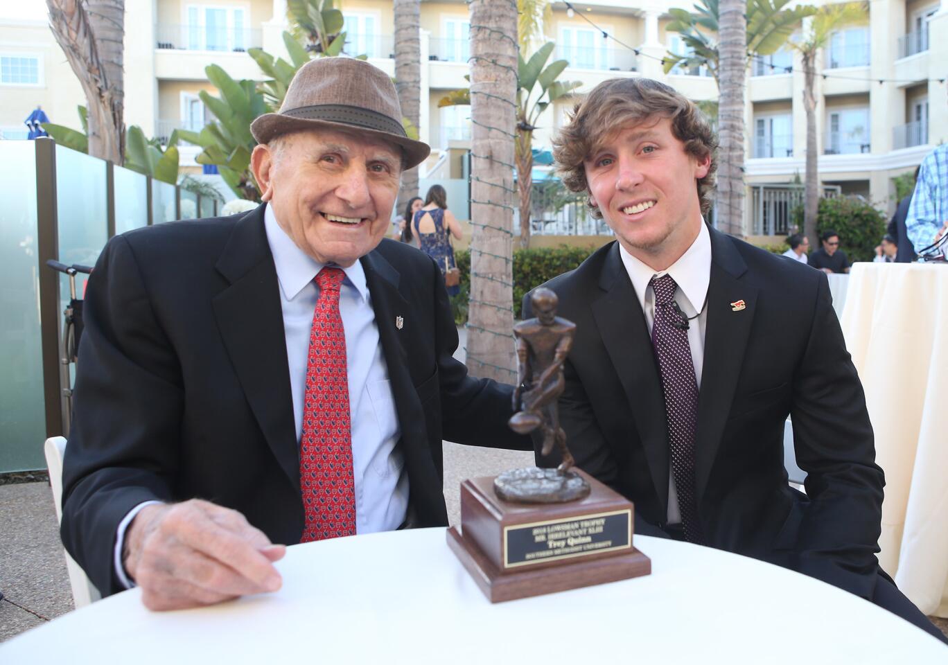 Mr. Irrelevant founder Paul Salata shares a laugh with 2018 Mr. Irrelevant Trey Quinn over the Lowsman Trophy prior to the Lowsman Trophy Banquet at the Balboa Bay Resort on Monday.