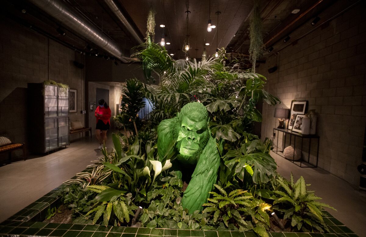 A green gorilla statue in the middle of a planter
