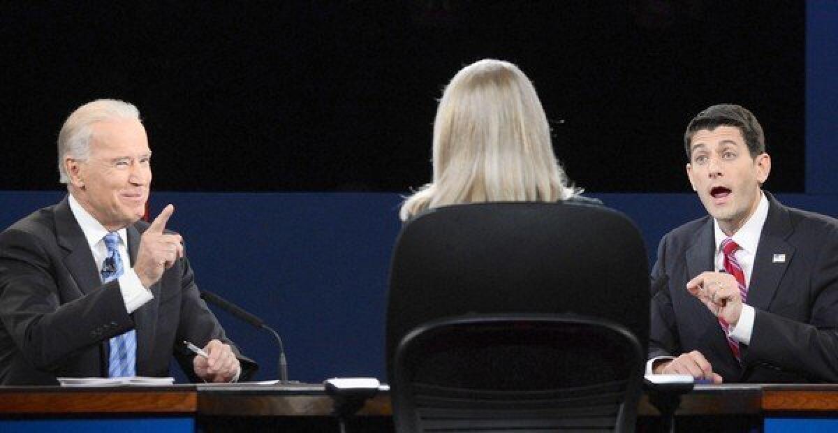 Vice President Joe Biden, left, and Republican vice presidential nominee Paul Ryan compete over a point in their debate in Danville, Ky. Between them is moderator Martha Raddatz.