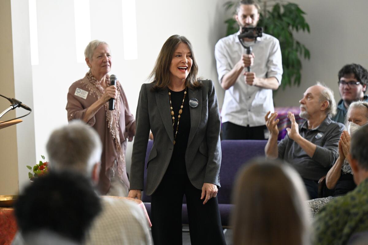 Democratic presidential candidate Marianne Williamson, center, is cheered by the crowd.