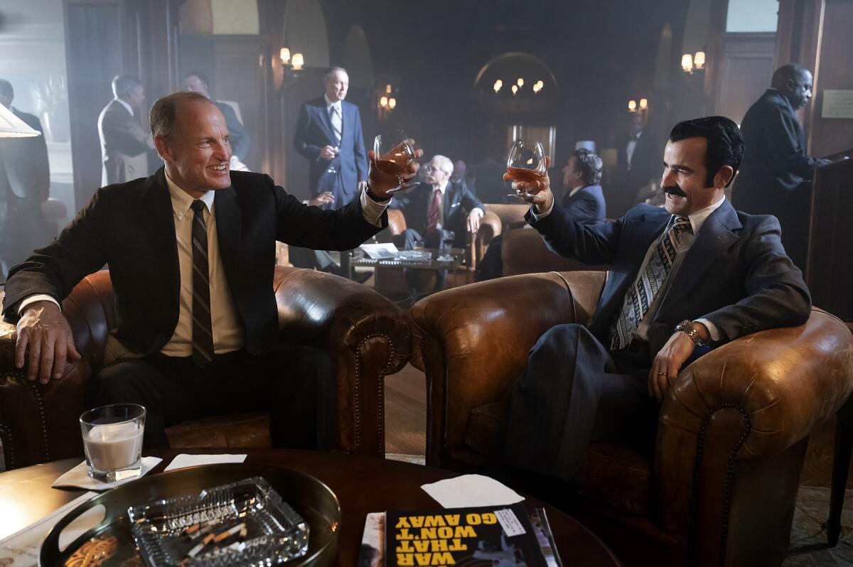 Woody Harrelson and Justin Theroux raise their glasses to toast in "White House Plumbers."