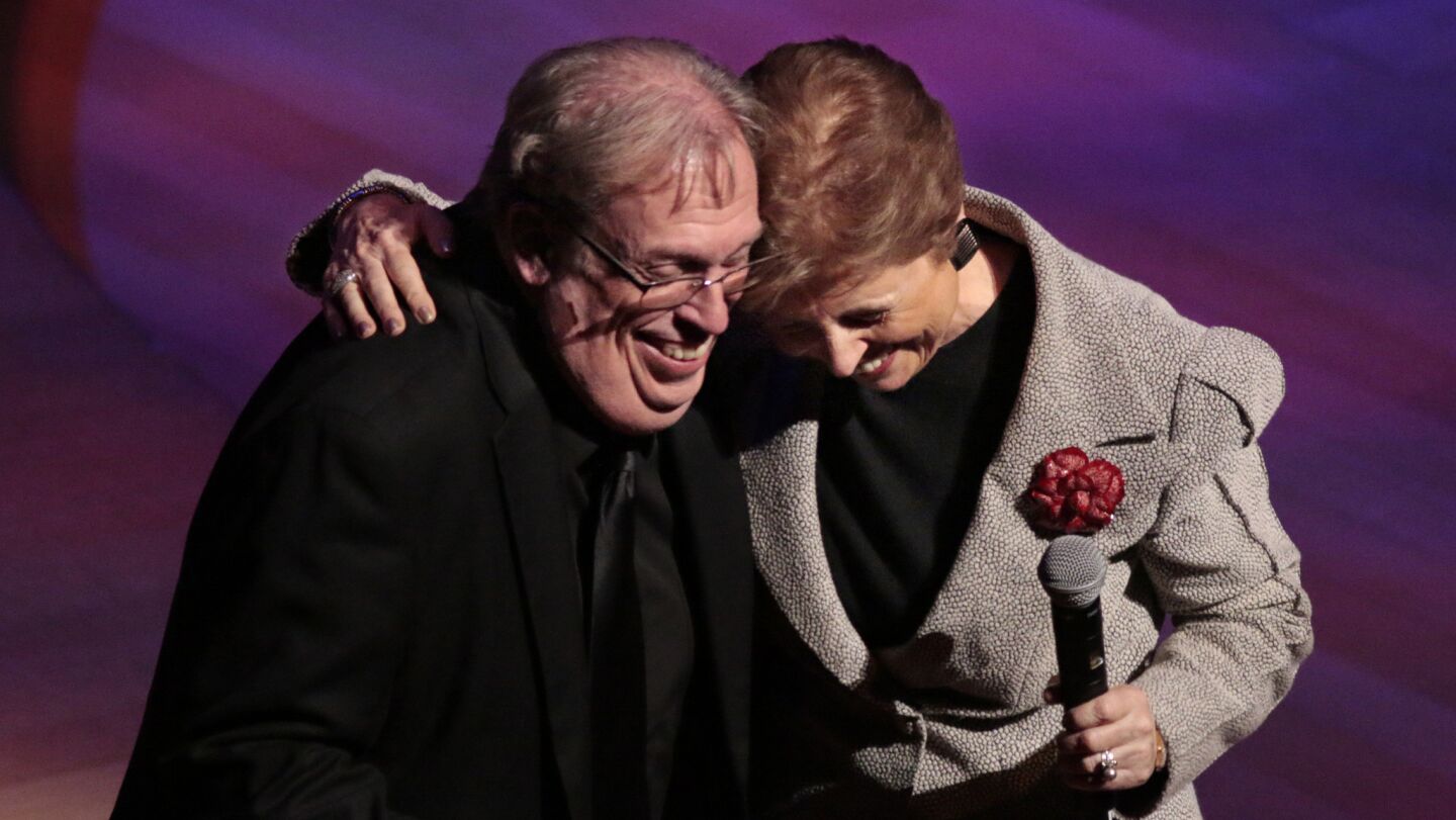 L.A. Philharmonic President Deborah Borda gives organ conservator Philip Smith, left, a hug after introducing him on stage at Walt Disney Concert Hall on Nov. 23, 2014.