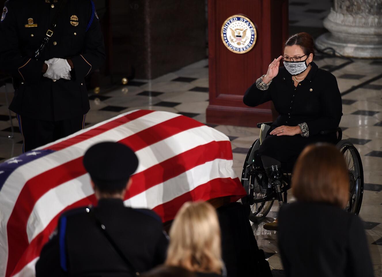 Sen. Tammy Duckworth salutes Justice Ruth Bader Ginsburg during a memorial service at the U.S. Capitol