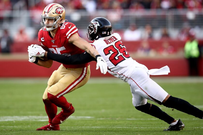 SANTA CLARA, CALIFORNIA - DECEMBER 15: Tight end George Kittle #85 of the San Francisco 49ers carries the ball against the defense of cornerback Isaiah Oliver #26 of the Atlanta Falcons during the game at Levi's Stadium on December 15, 2019 in Santa Clara, California. (Photo by Ezra Shaw/Getty Images)