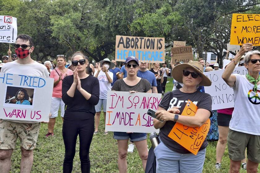 Abortion-rights marchers hold signs during a rally Friday, June 24, 2022 in St. Petersburg, Fla. The Supreme Court on Friday stripped away women’s constitutional protections for abortion, a fundamental and deeply personal change for Americans' lives after nearly a half-century under Roe v. Wade. The court’s overturning of the landmark court ruling is likely to lead to abortion bans in roughly half the states. (Jefferee Woo/Tampa Bay Times via AP)