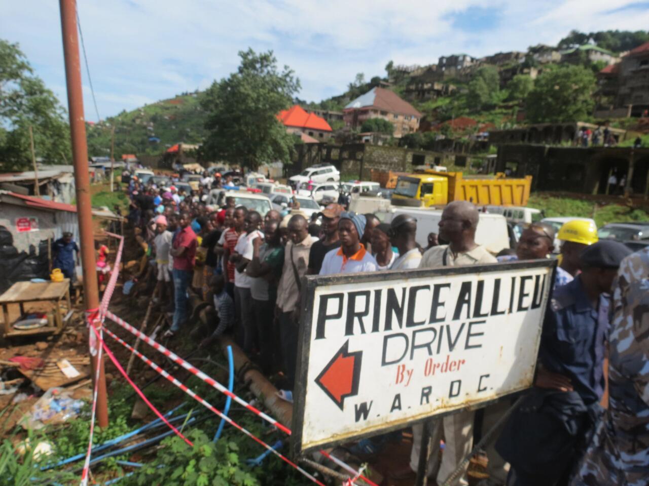 Residents gather to watch the rescue operations at the side of a mudslide in the Sierra Leone capital, Freetown.