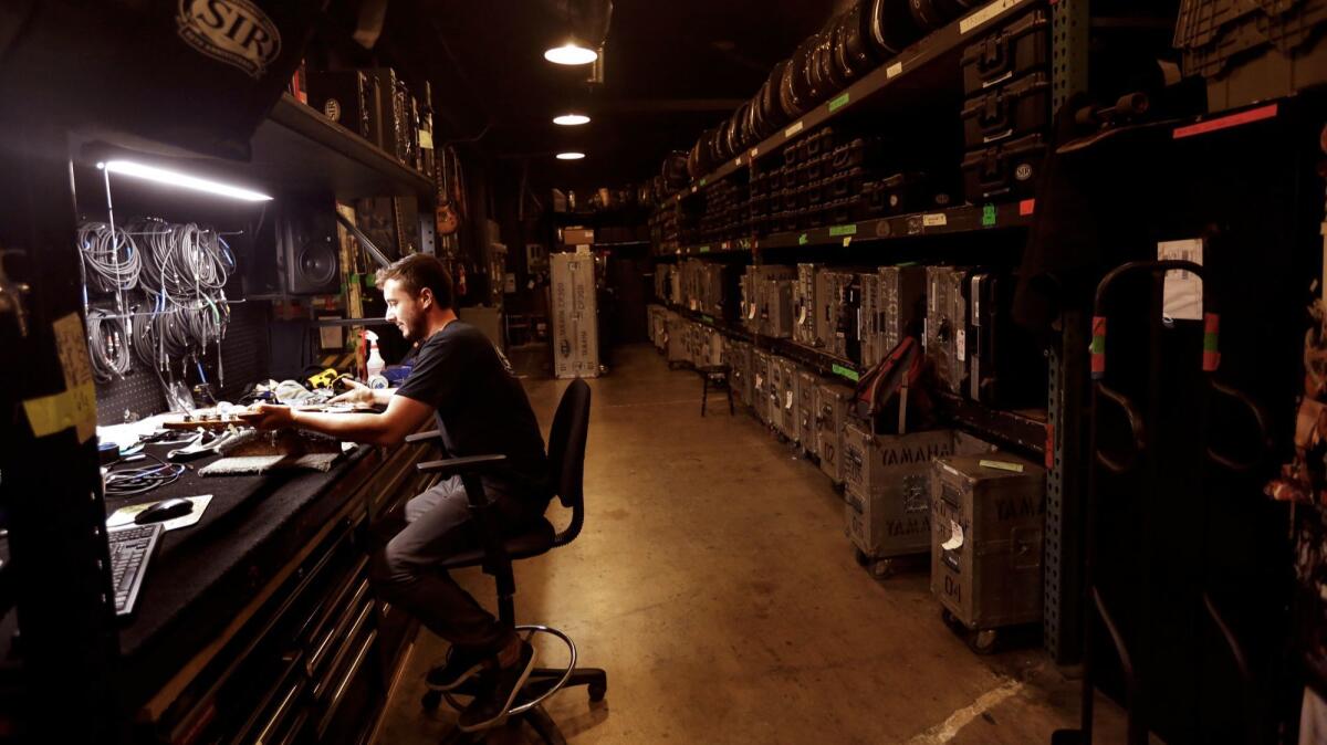 Backline technician Matthew Giordano checks an electrical guitar atStudio Instrument Rentals (SIR) on Sunset Blvd.