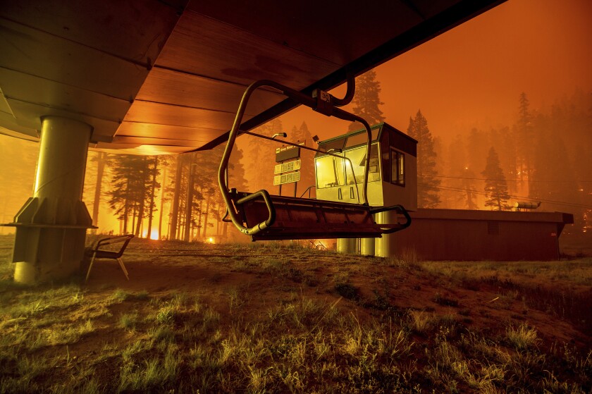 FILE — Seen in a long camera exposure, the Caldor Fire burns at Sierra-at-Tahoe ski resort on Monday, Aug. 30, 2021, in Eldorado National Forest, Calif. A father and son have been arrested on suspicion of starting a massive California wildfire that forced tens of thousands to flee the Lake Tahoe area earlier this year, officials said Wednesday, Dec. 8, 2021. The El Dorado County District Attorney’s office said in a statement that David Scott Smith and his son, Travis Shane Smith, are accused of reckless arson in a warrant issued before formal charges are filed. (AP Photo/Noah Berger, File)