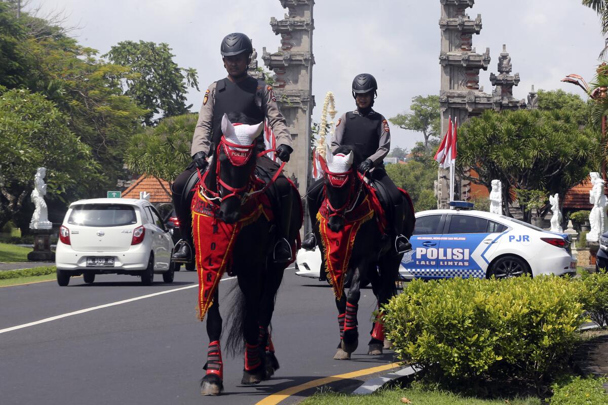 Mounted police patrol a street ahead of the G20 Summit in Nusa Dua, Bali, Indonesia, Sunday, Nov. 13, 2022. Indonesia is gearing up to host the gathering of the leaders of the world's biggest economies this week. (AP Photo/Firdia Lisnawati)