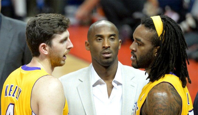 Kobe Bryant, center, listens as teammates Ryan Kelly, left, and Jordan Hill talk during a timeout in a preseason game against the Golden State Warriors in Shanghai on Oct. 18.