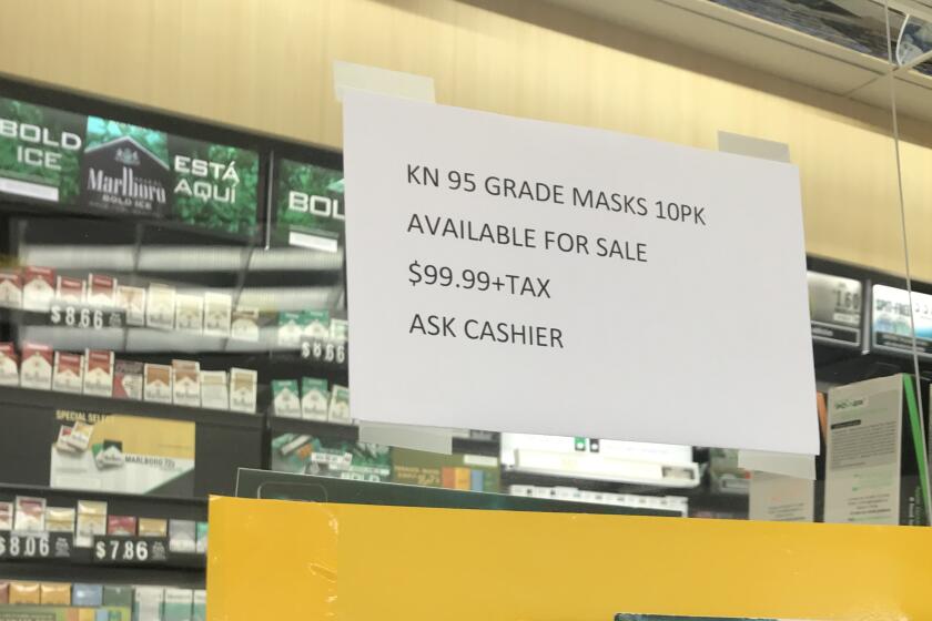 A sign advertising medical-grade respirators at a dramatically marked-up price was taped over the counter Wednesday at an ARCO gas station in Bonita.