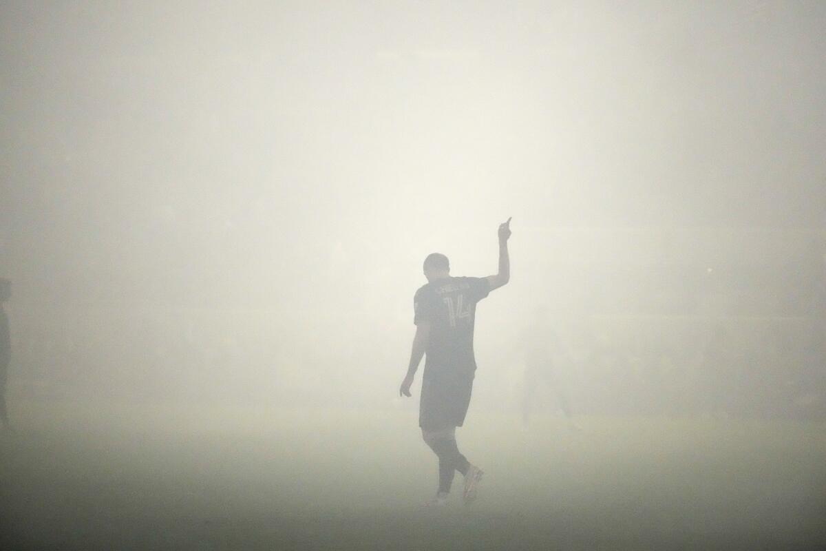 LAFC defender Giorgio Chiellini gestures amid smoke that delayed play during the first half of a playoff match.