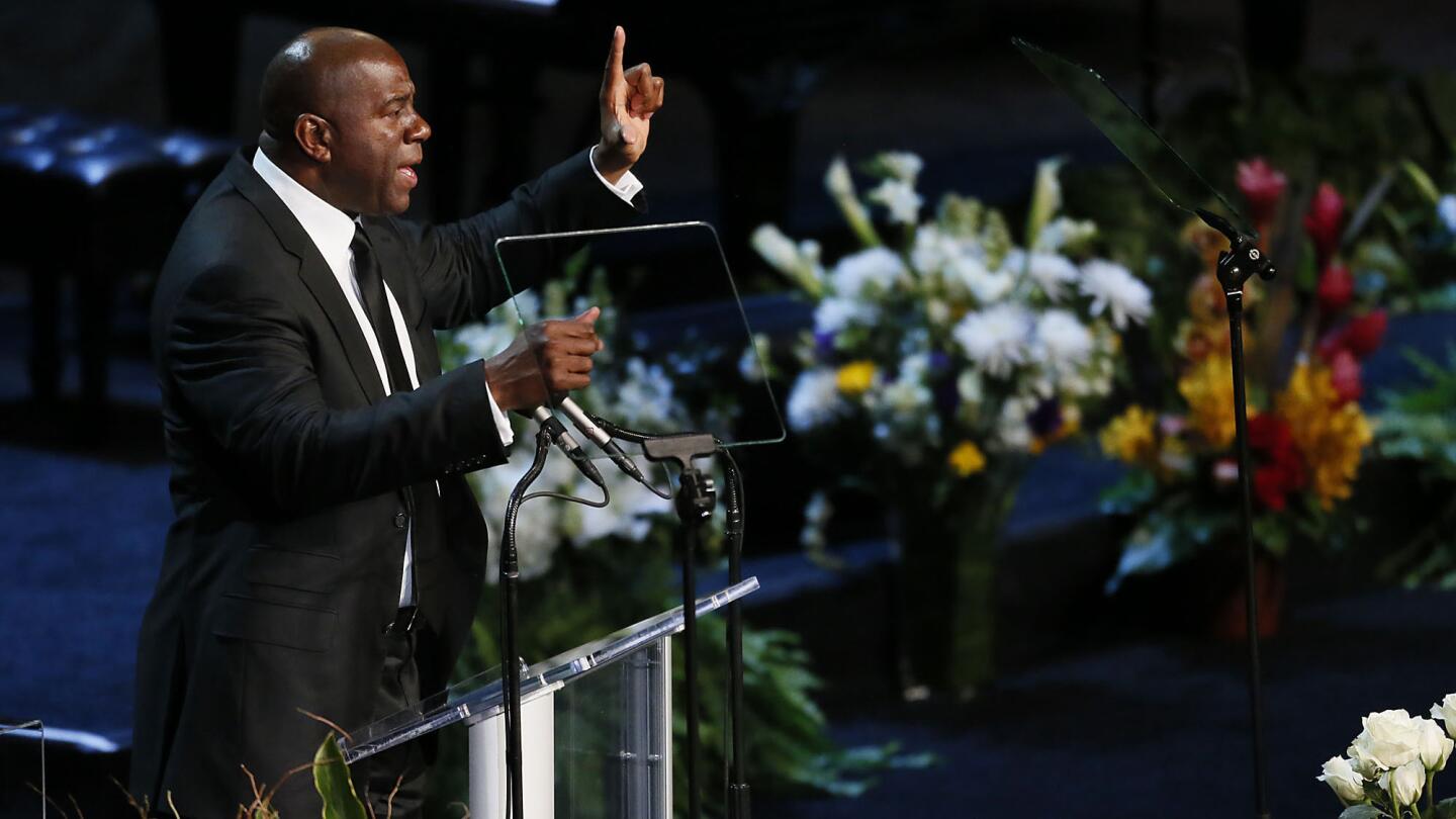 Lakers great Magic Johnson encourages mourners to flash an "L" for Lakers as he eulogizes at a memorial service for Lakers owner Jerry Buss at Nokia Theater in February 2013.